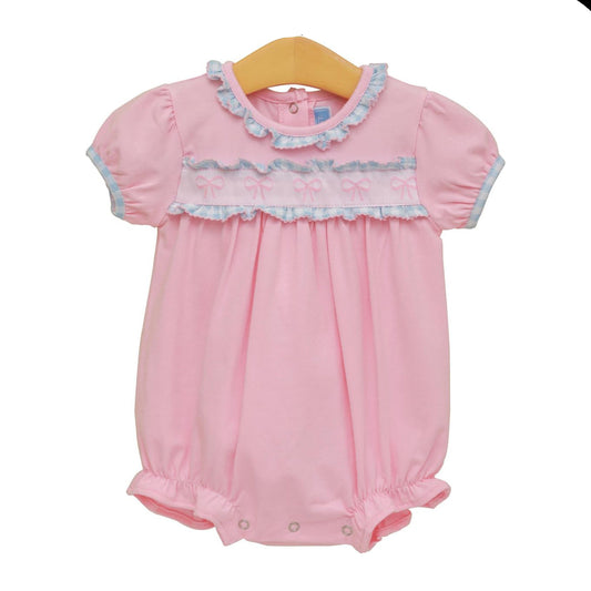 Pink baby romper with lace details on a white background